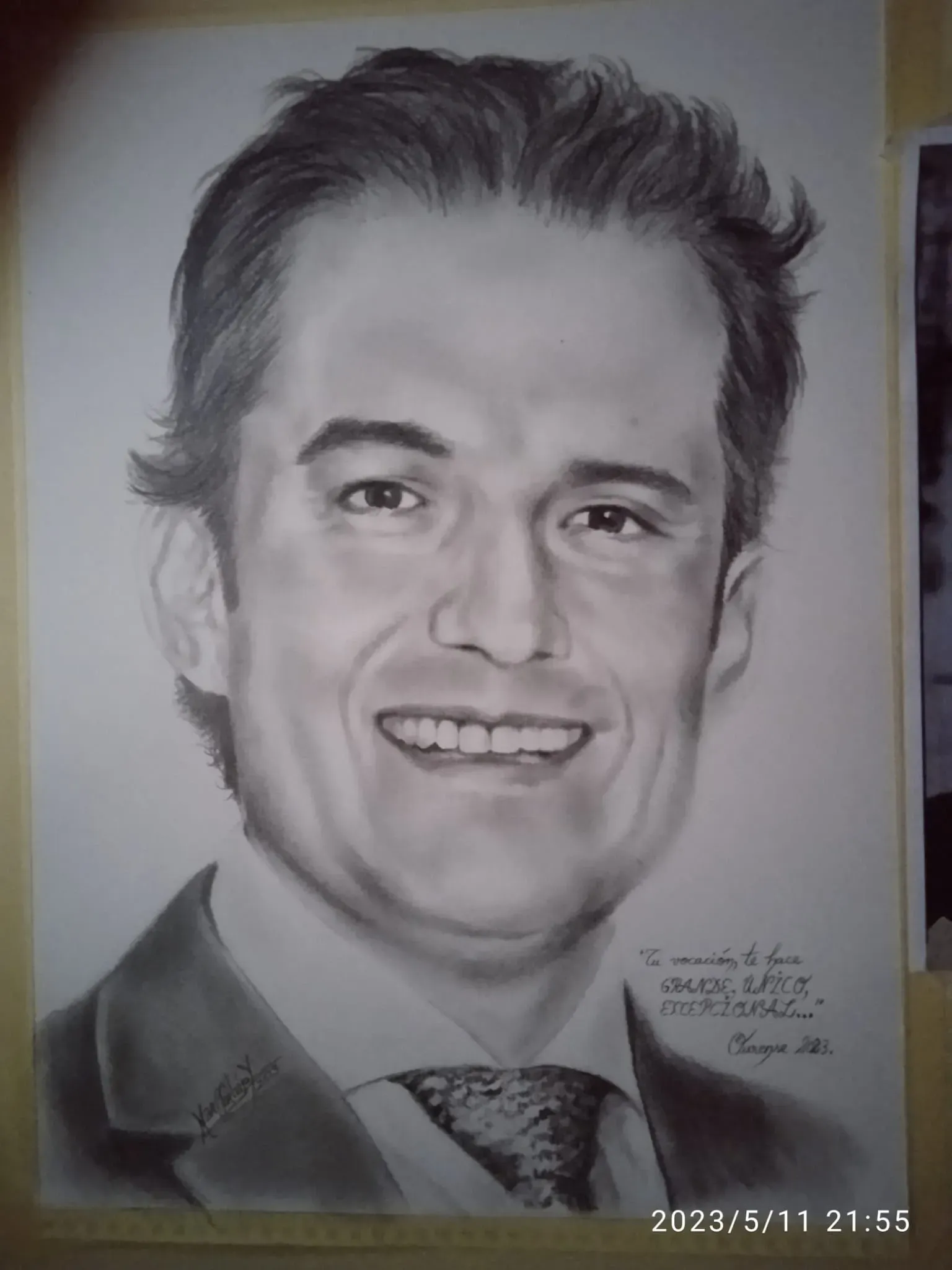 Retrato a lápiz de un hombre sonriente con camisa de cuello y corbata, firmado en la parte inferior derecha.