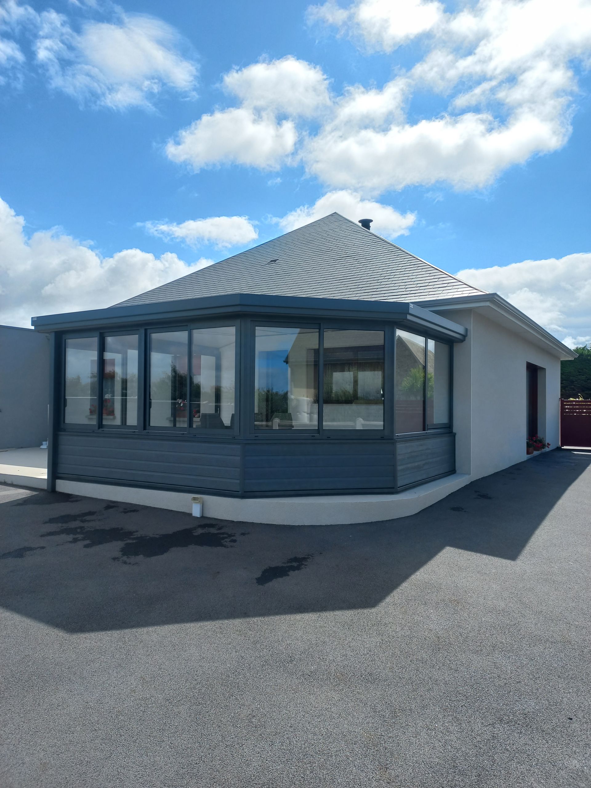 Petit bâtiment commercial doté de grandes fenêtres et d’un toit métallique, sous un ciel bleu éclatant
