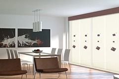 Comedor moderno con mesa, sillas, obras de arte y cortinas corredizas.