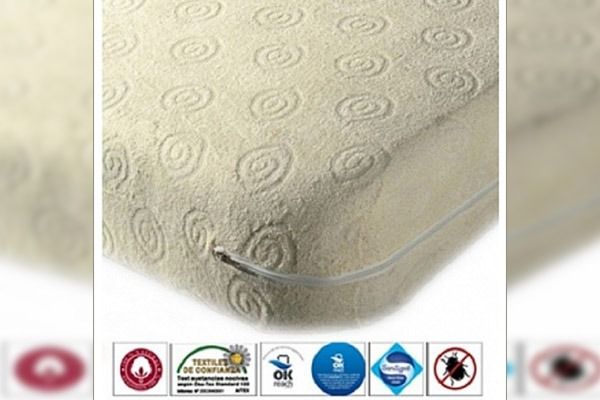 Colchón color crema con estampado en espiral y cremallera en el borde.