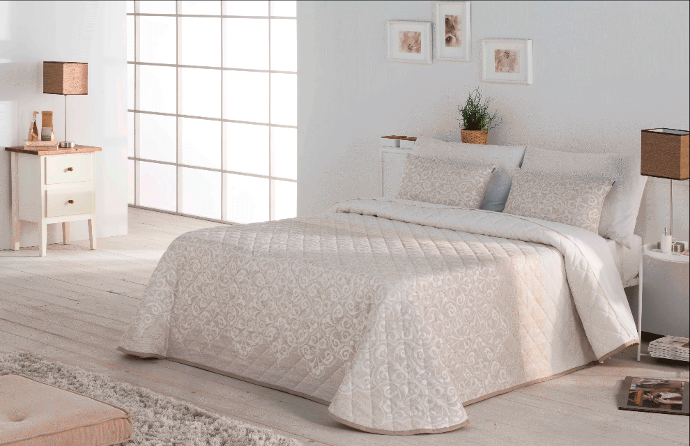 Dormitorio con ropa de cama acolchada color beige, decoración neutra y ventana grande.