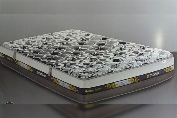 Colchón con superficie estampada en tonos grises, negros y blancos; laterales marrones y detalles dorados.