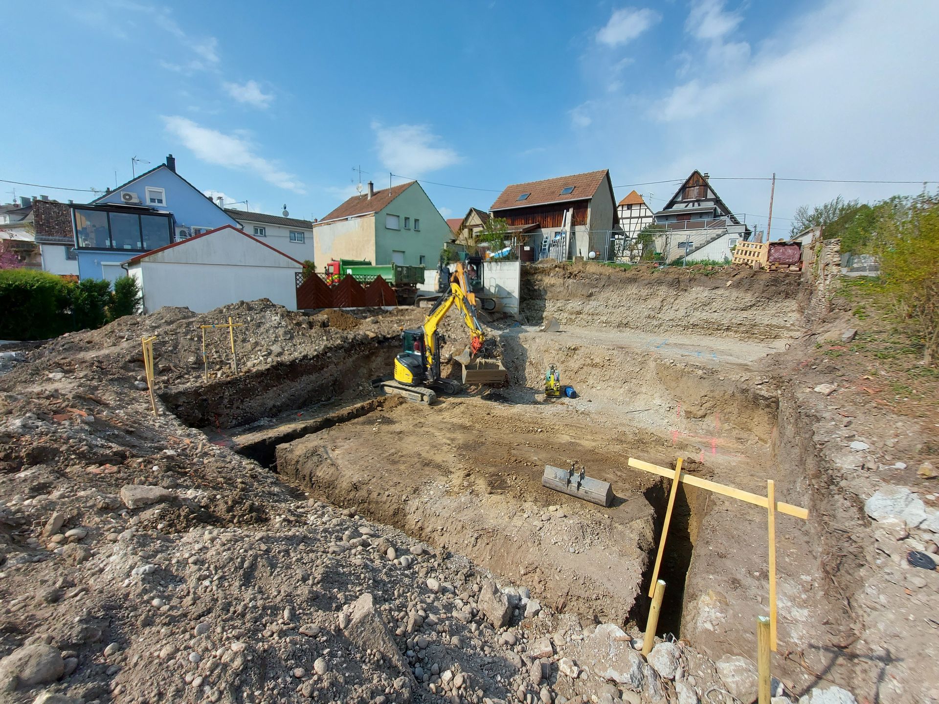 Des travaux de terrassement avec des tranchées et un engin de chantier.