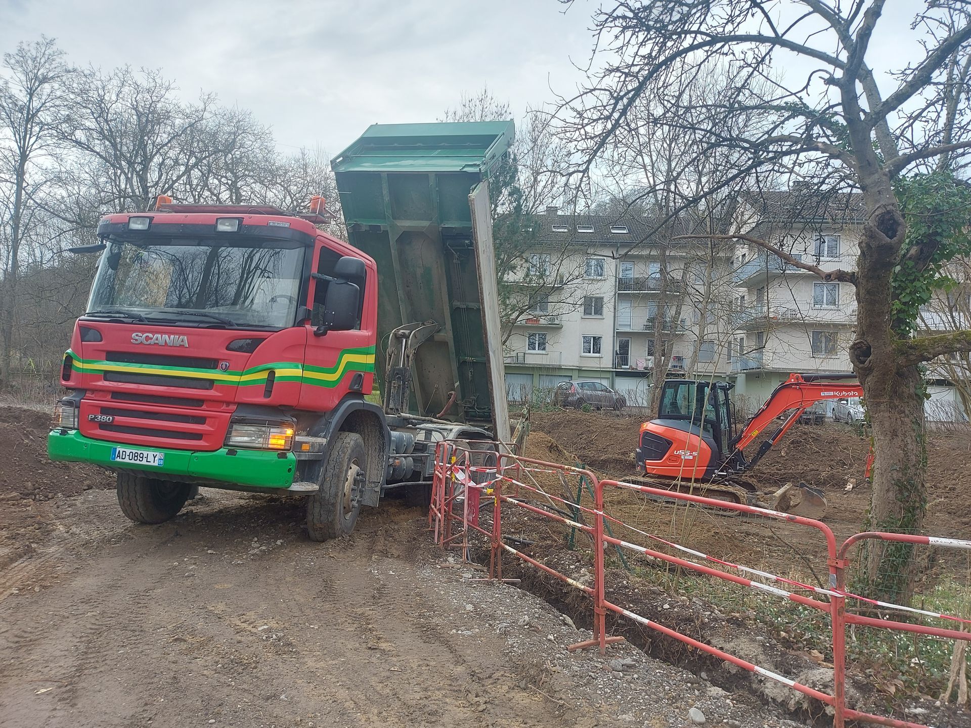 Un camion qui déverse de la terre sur un chantier.