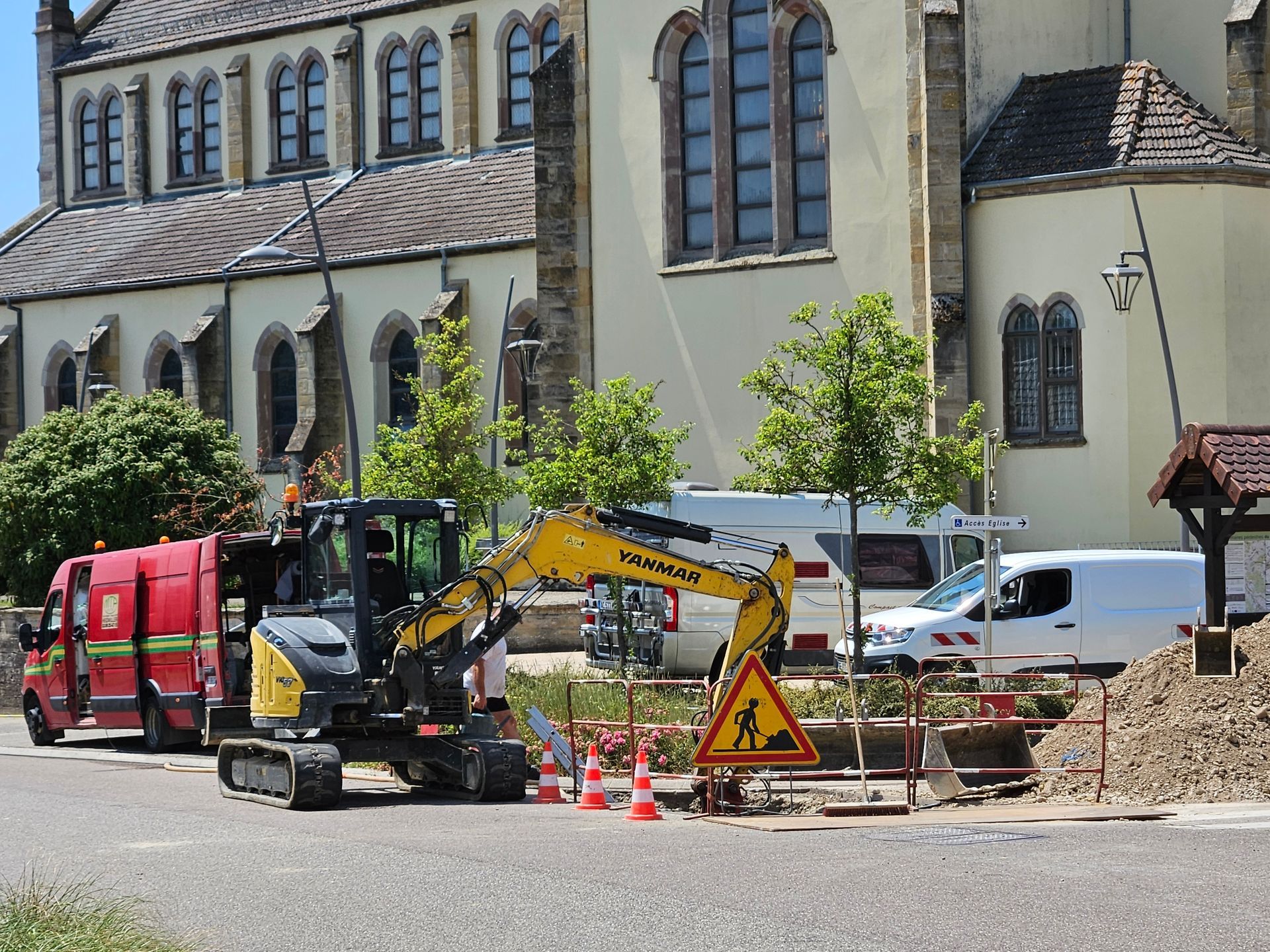 Un chantier d'alimentation en eau potable avec des engins et des barrières de sécurité.