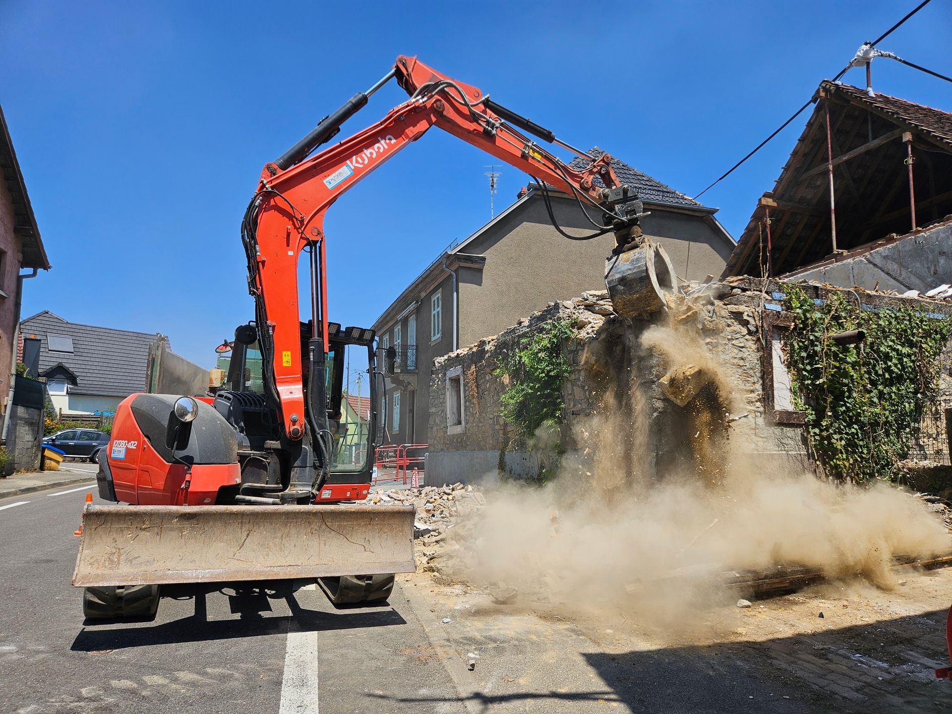 Un engin de chantier qui démolit une maison.