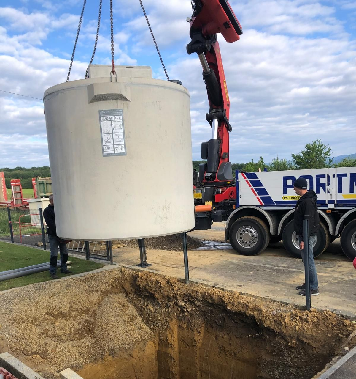 Pose d'une cuve en béton à l'aide d'un camion-grue.