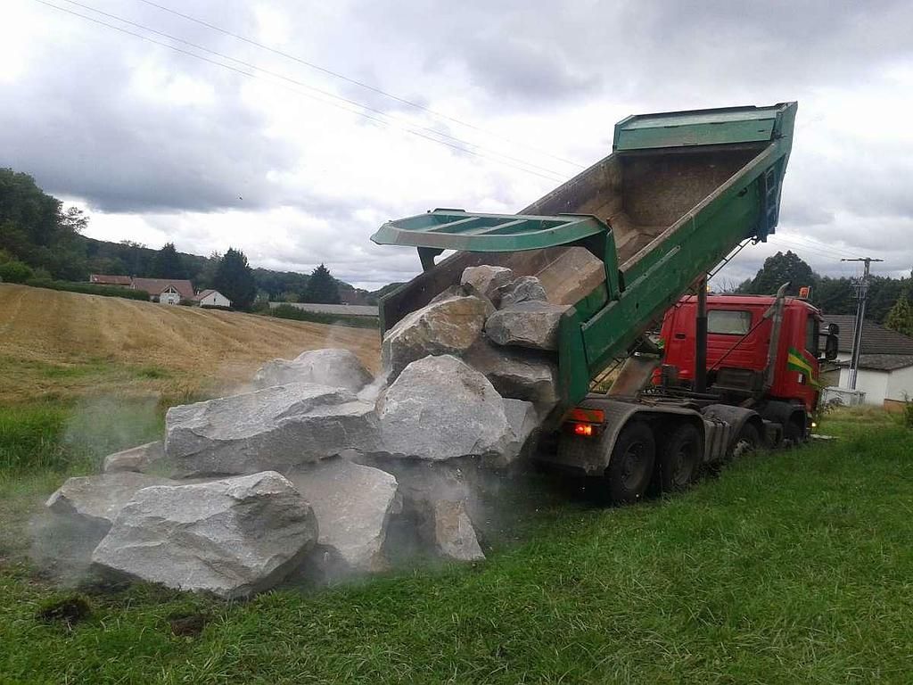 Un camion qui décharge des pierres d'enrochement.