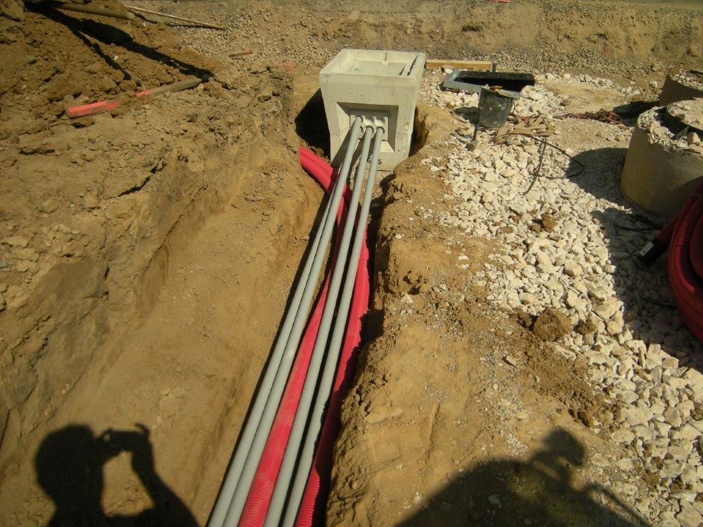Installation de câbles et de gaines dans une tranchée.