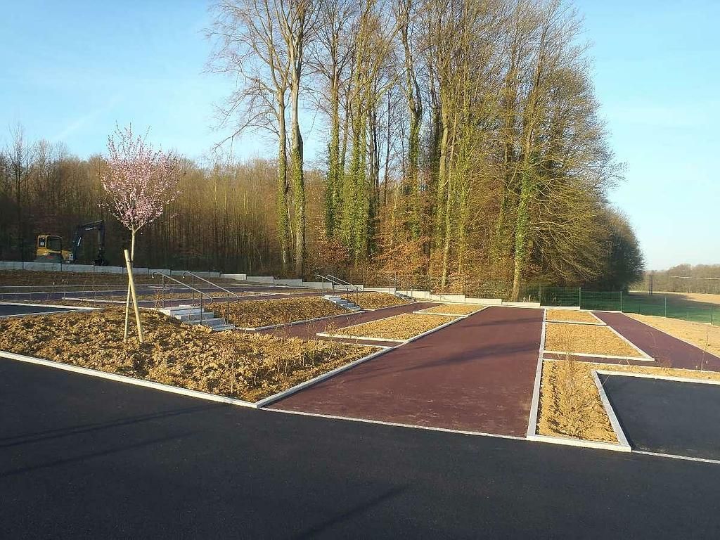Des allées en enrobé, aménagées et structurées avec des bordures en béton.