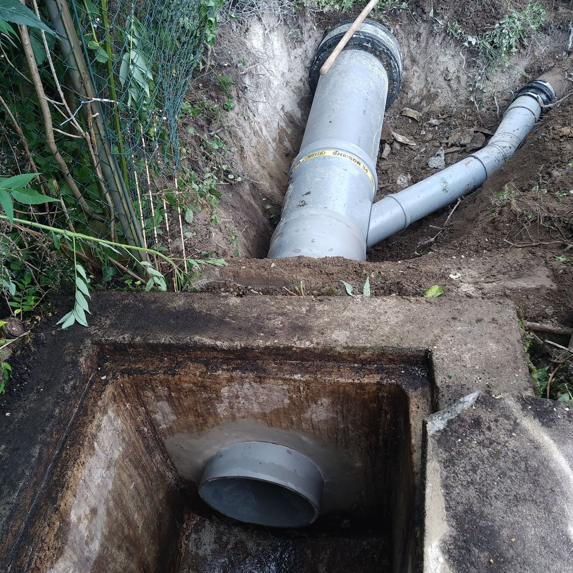 Des tuyaux de drainage remplacés, reliés à un regard d'assainissement.