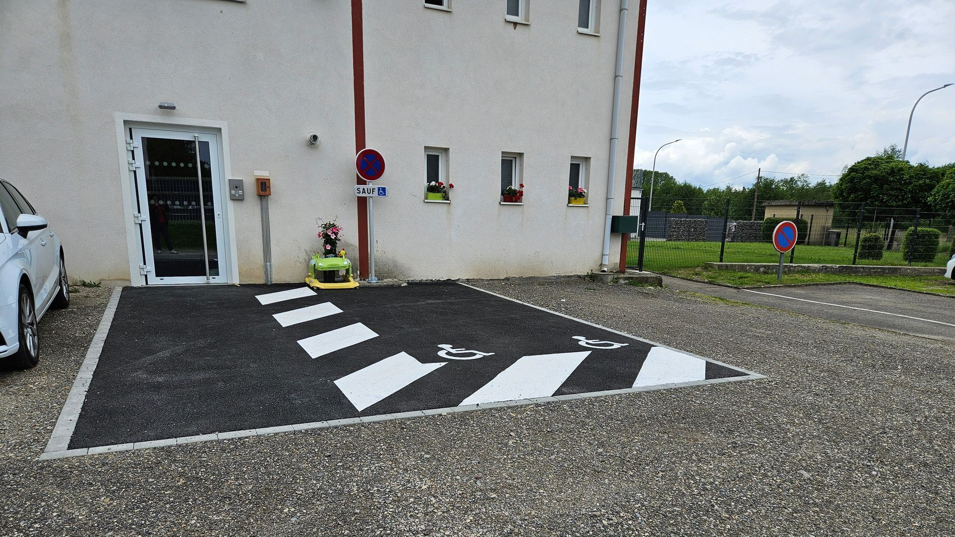 Une place de parking en enrobé pour personnes handicapées.