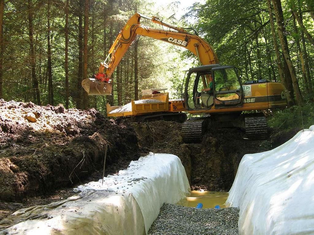 Une pelleteuse jaune déblaye la terre.