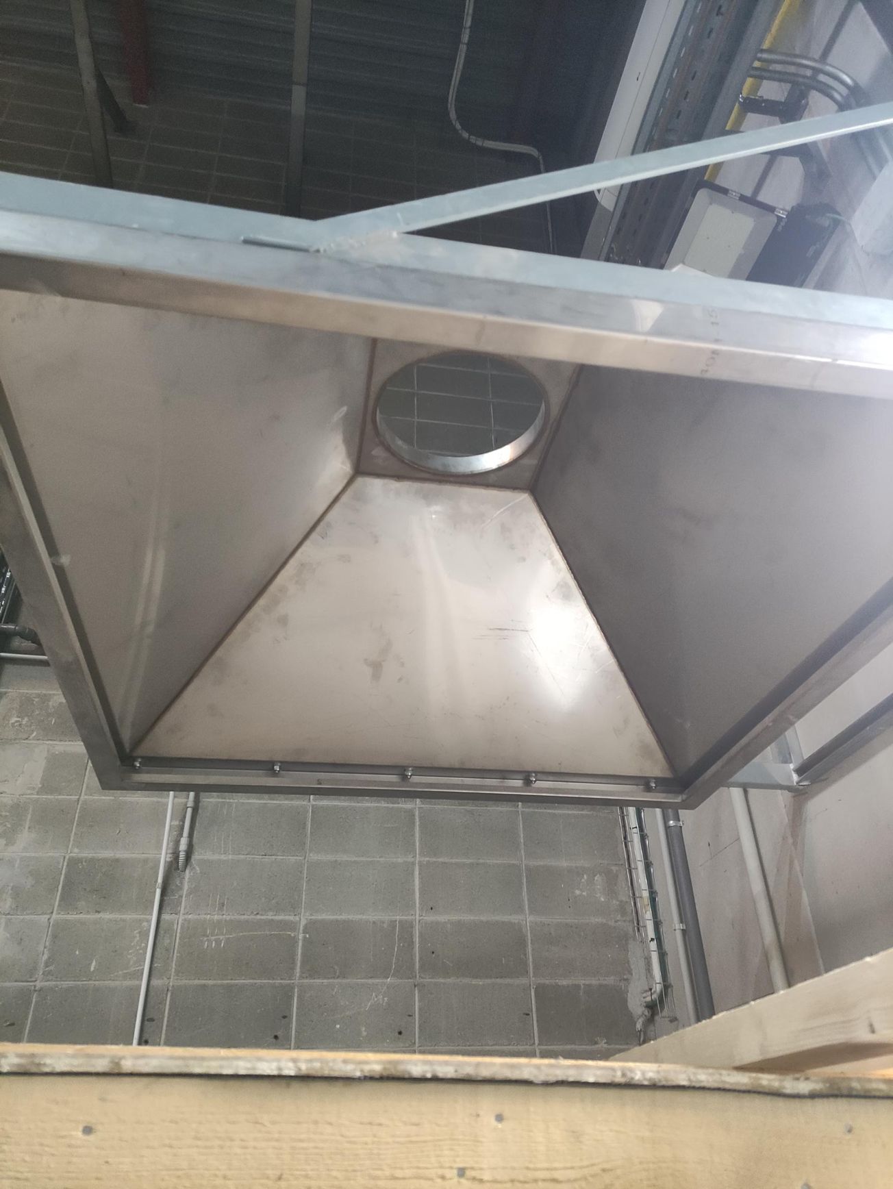 Una campana de acero inoxidable cuelga del techo de un edificio.