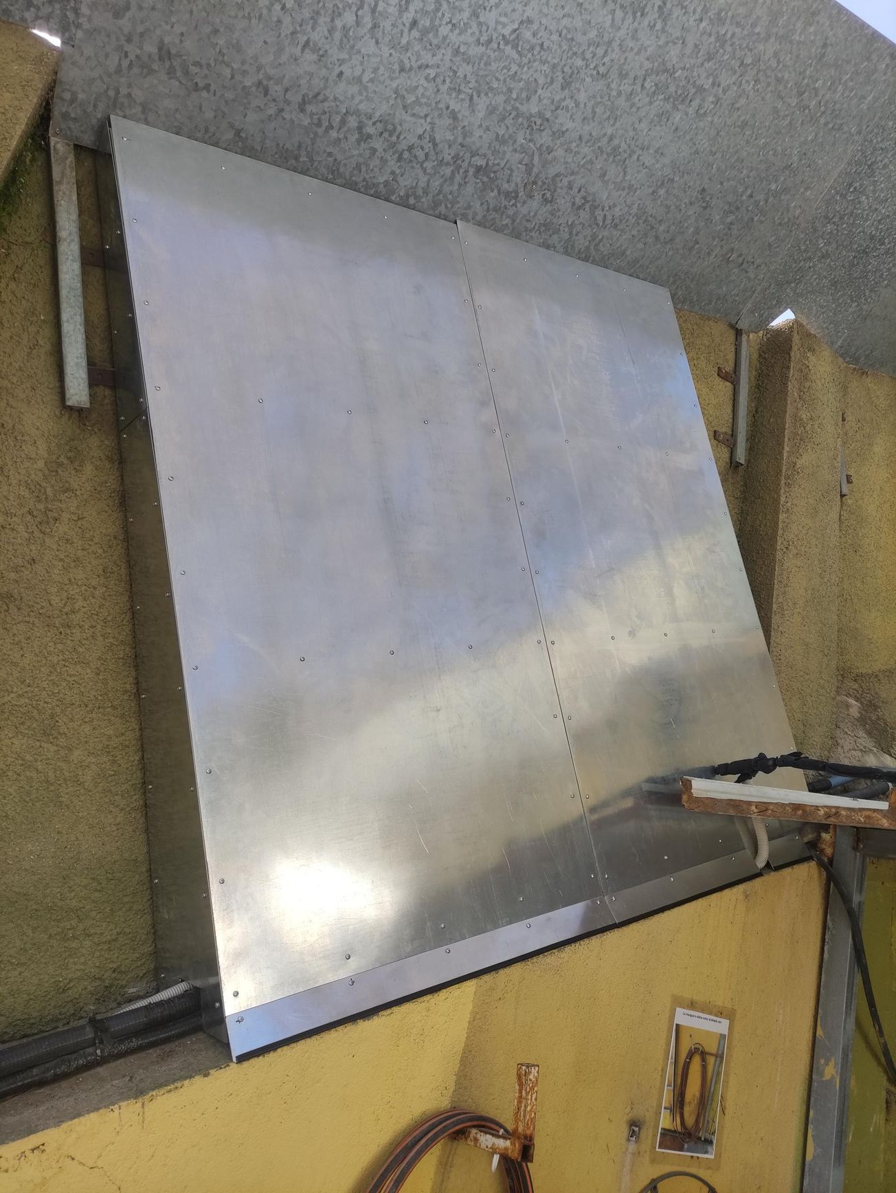 Una gran campana de acero inoxidable cuelga del techo de un edificio.