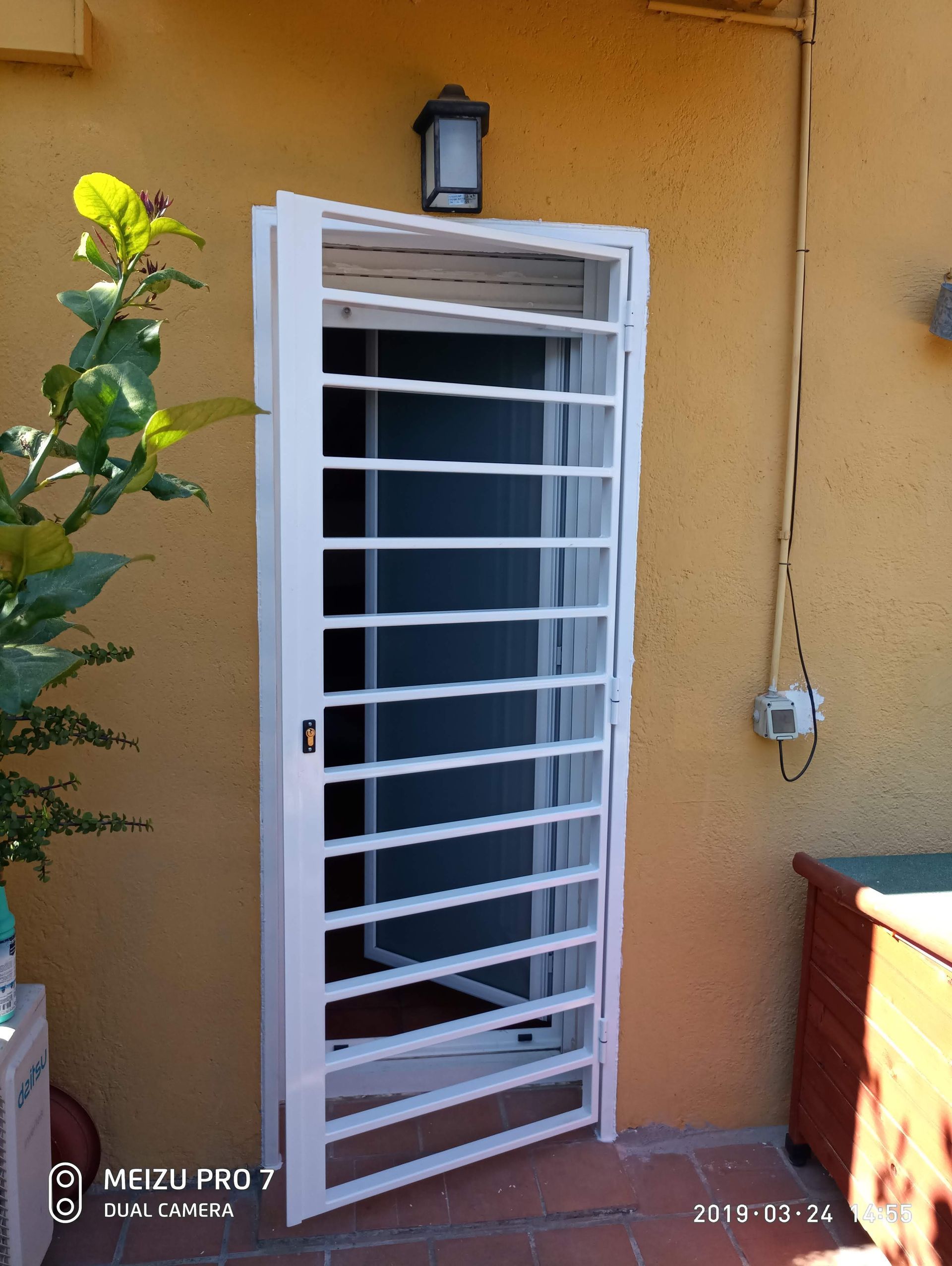 Una valla de hierro forjado está delante de una casa.