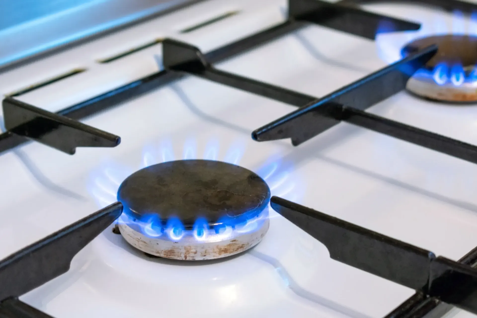 Un primer plano de una estufa de gas con llamas azules saliendo de ella.