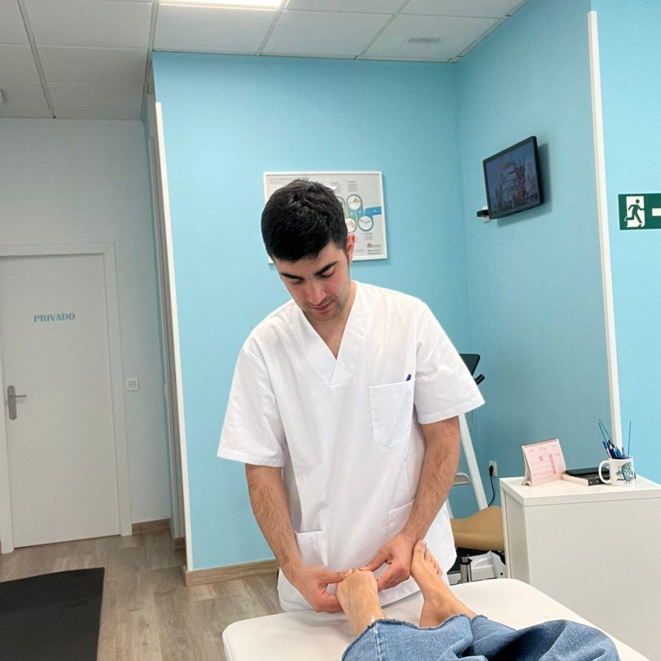 Un médico con uniforme blanco realiza una exploración física del pie de un paciente