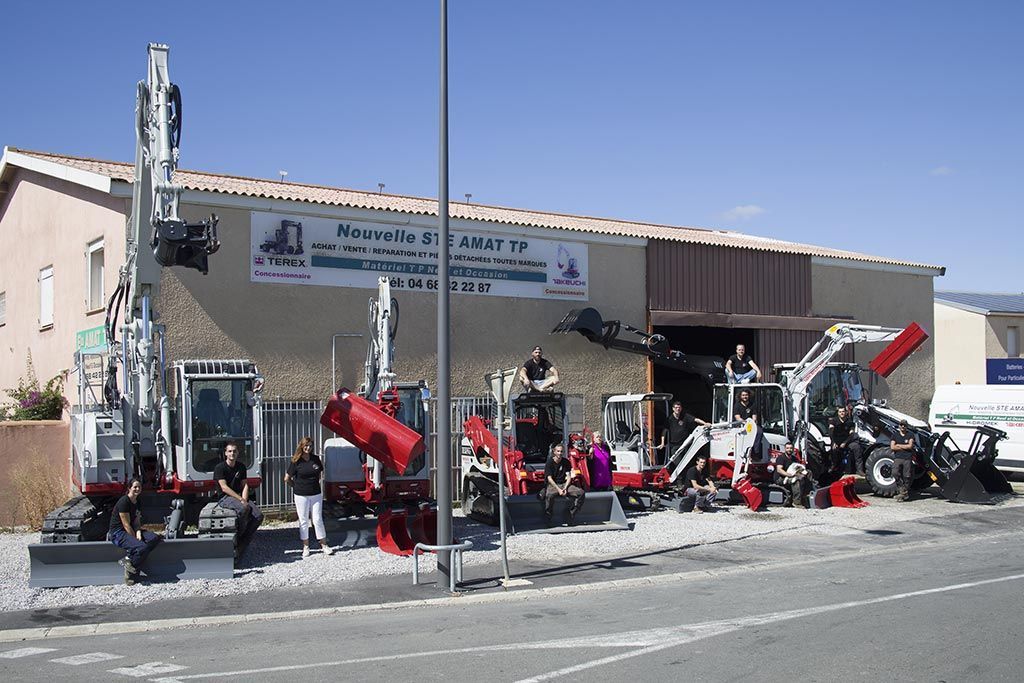 Portrait d'équipe AMAT TP positionnée autour d'engins de travaux publics