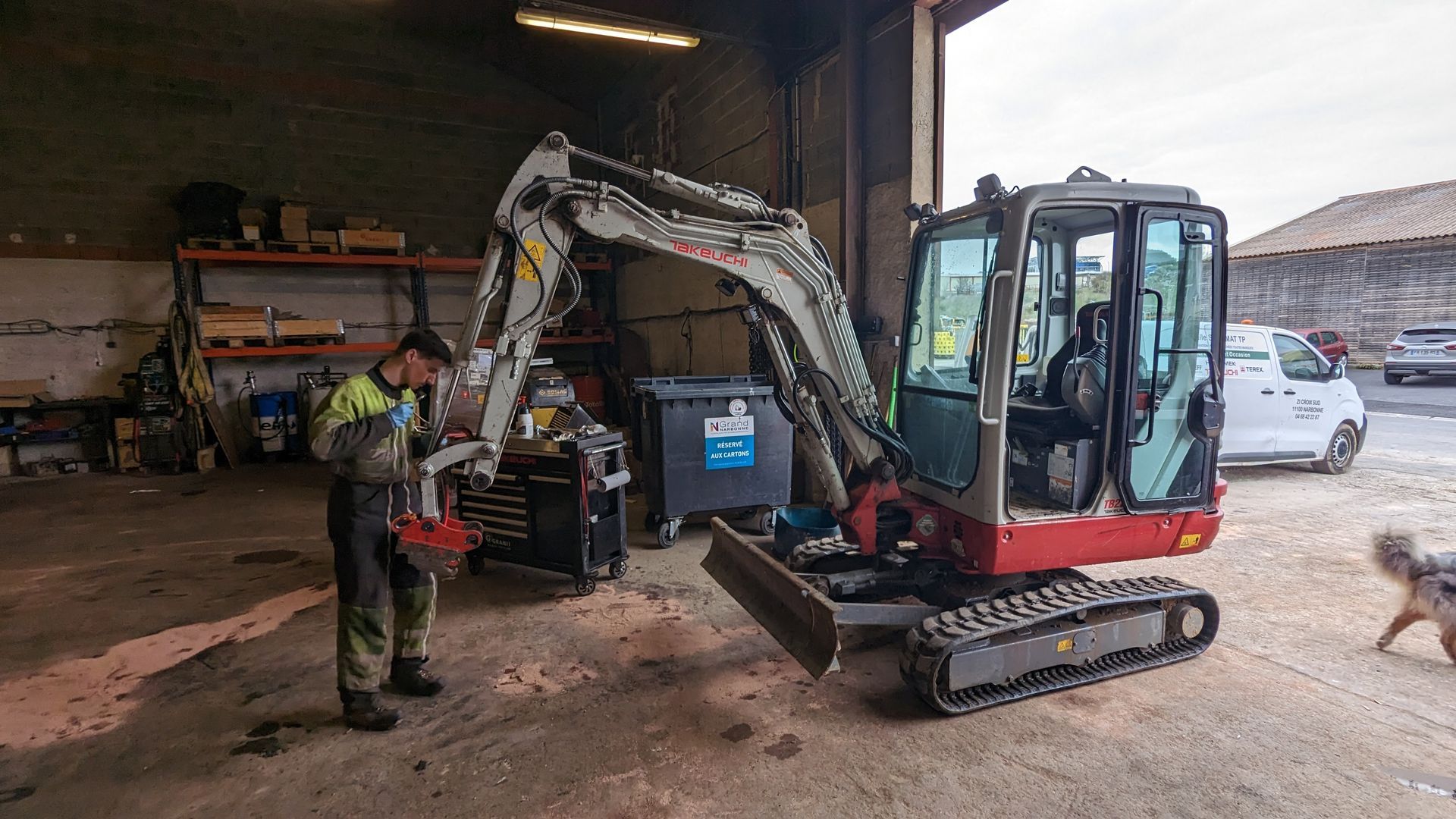 Employé en cours de maintenance d'un tractopelle