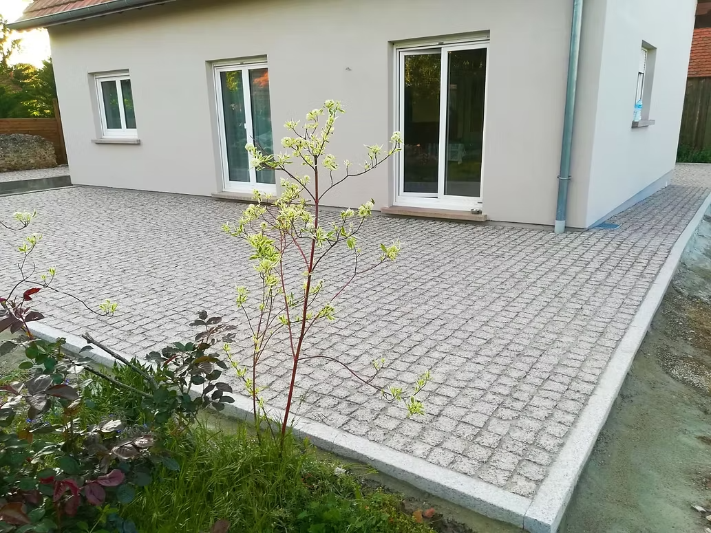 Extérieur d'une maison avec terrasse en pierre.