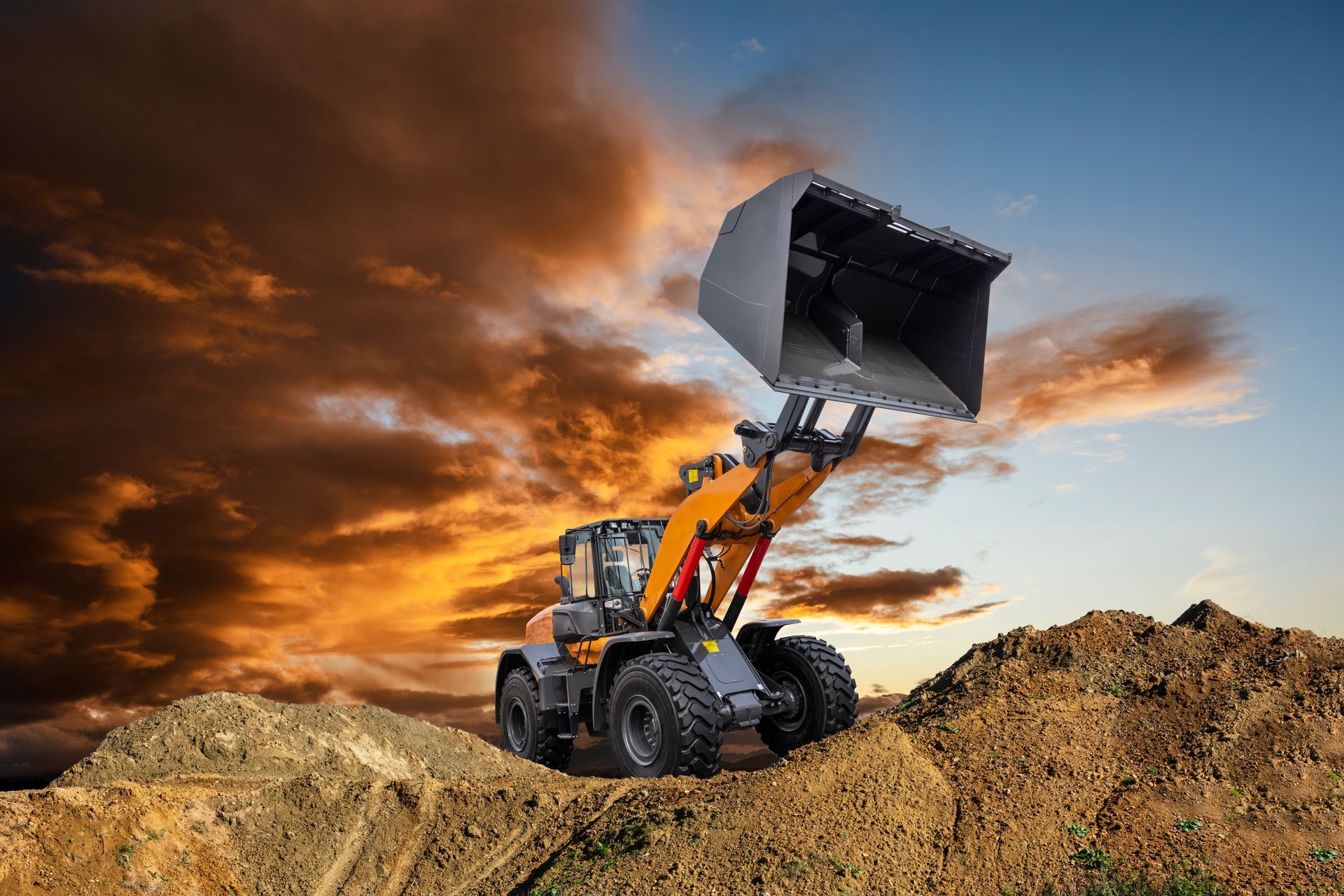 Chargeuse sur pneus déversant de la terre sur un chantier de construction.