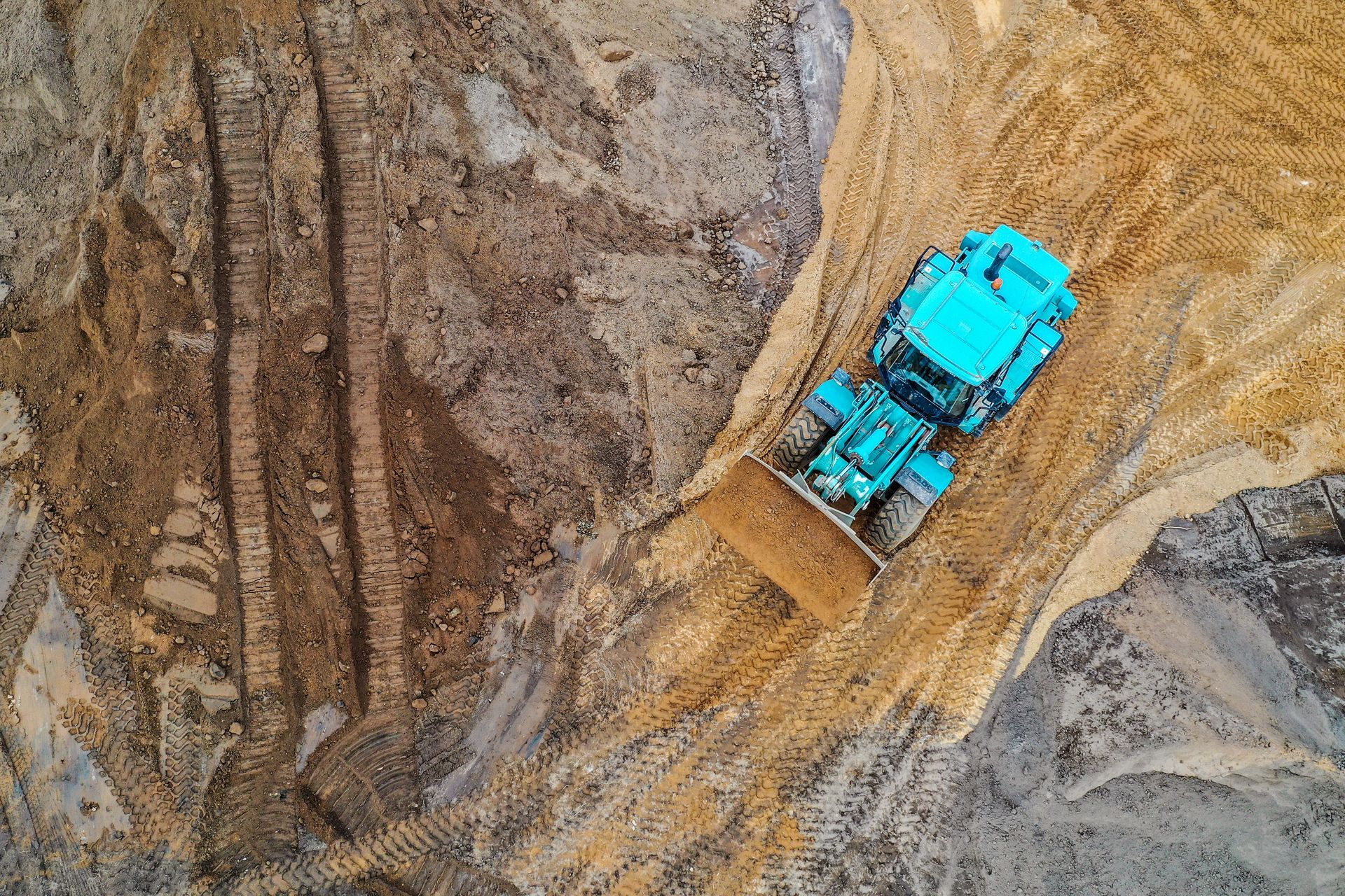Pelle mécanique bleue sur un talus de terre sur un chantier de construction.