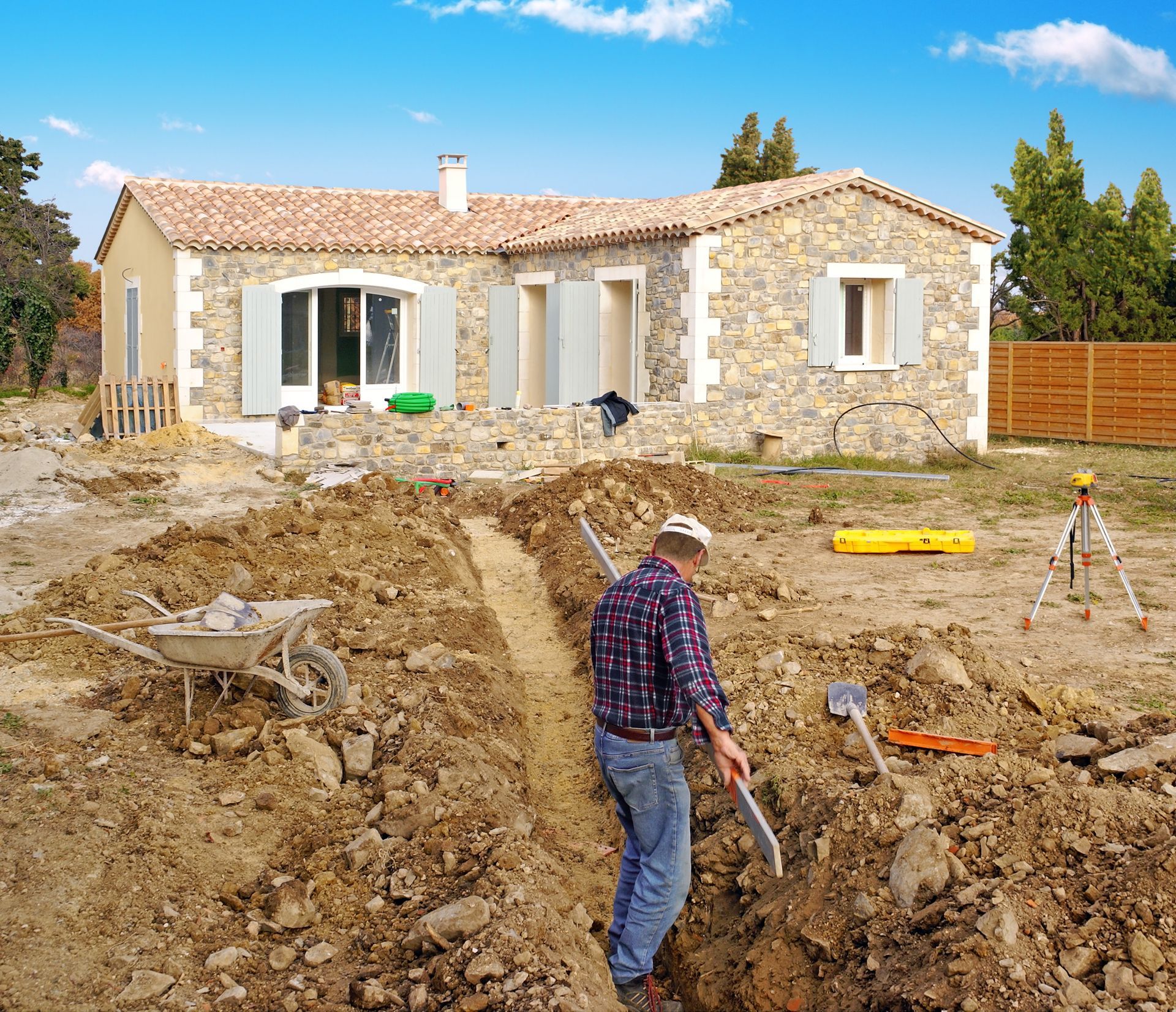Un homme se trouve dans une tranchée sur un chantier de construction de maison.