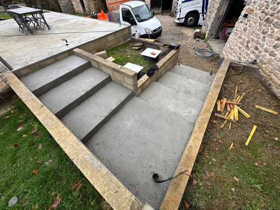 Marches et rampe en béton menant à une terrasse surélevée.