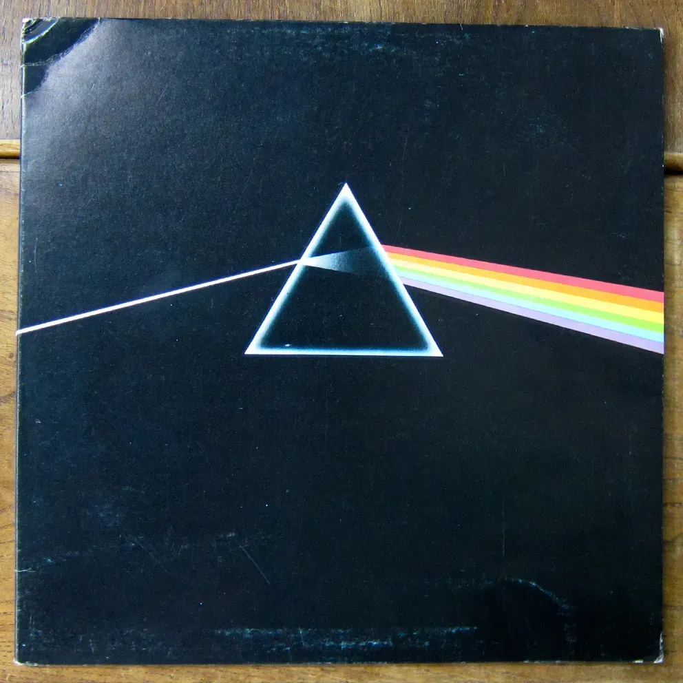 Portada del álbum A Dark Side of the Moon con un triángulo y un arcoíris.