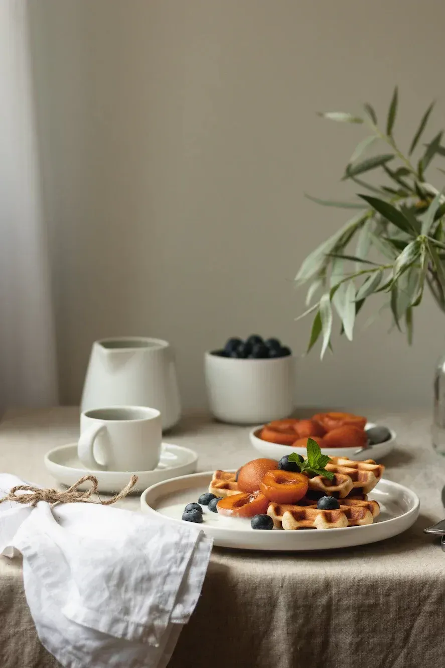 Una mesa cubierta con platos de comida y un jarrón con flores.