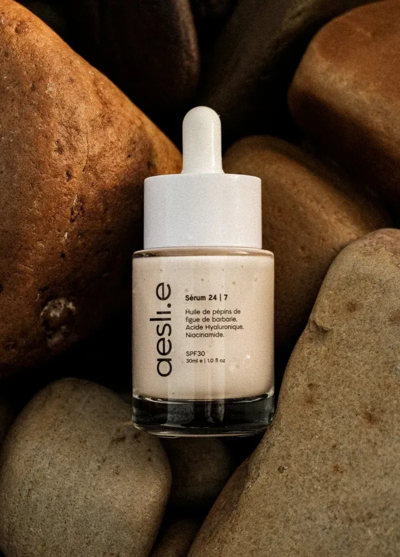 Main de femme avec une grosse bague en diamant en forme de poire, doigts près de ses lèvres.