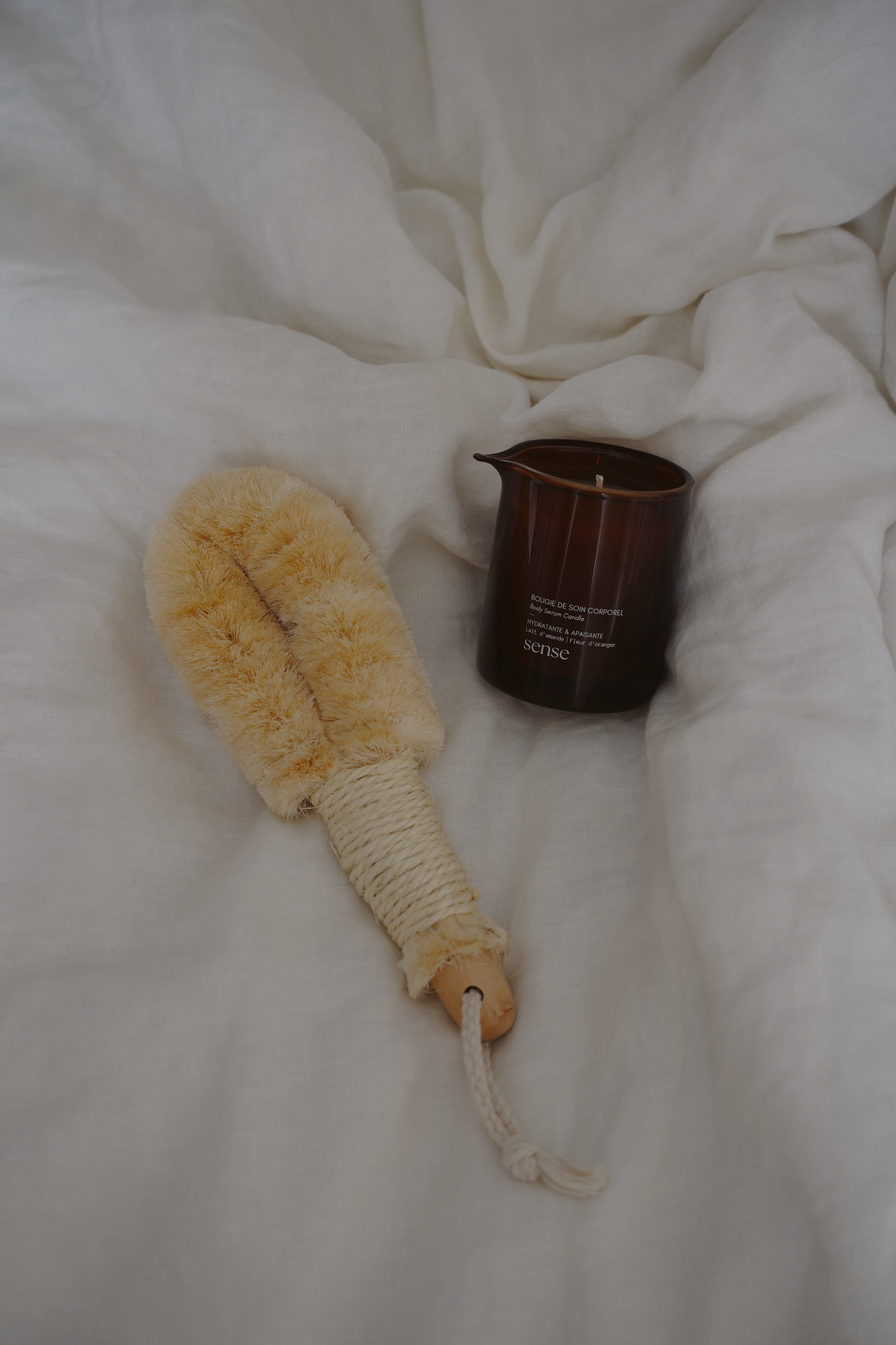 Produits de soin de la peau dans des bouteilles ambrées, présentées sur un plateau en bois avec des brins d'eucalyptus.