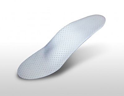 Una plantilla blanca con agujeros reposa sobre una superficie blanca.