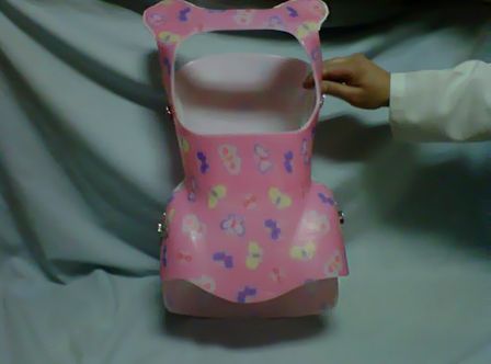 Una persona sostiene un corsé rosa con mariposas.