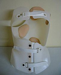 Un corsé blanco está sentado encima de una mesa blanca.