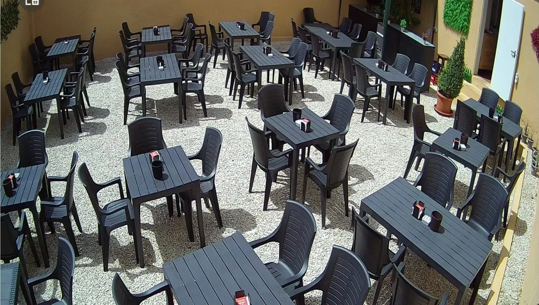Un restaurante con muchas mesas y sillas al aire libre.