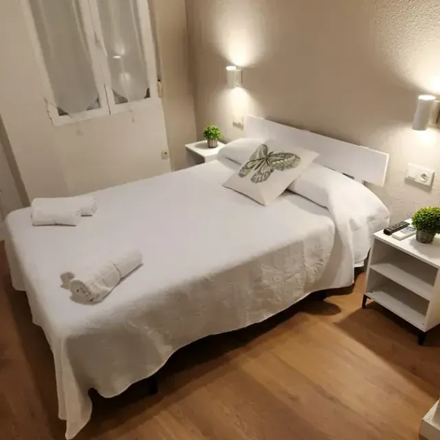 Un dormitorio con una cama con una almohada de mariposa encima.