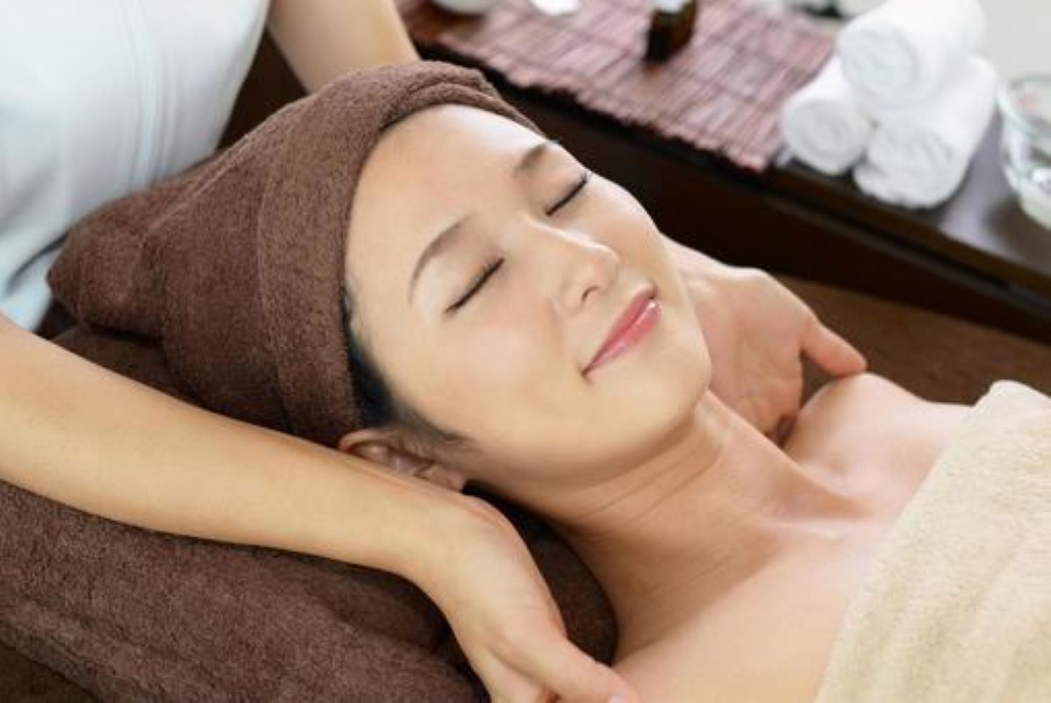 Intérieur d'une pièce de type spa avec un comptoir blanc, un canapé et un grand miroir sur le mur.