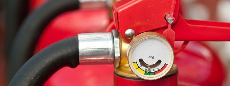 Caméra de sécurité fixée sur un mur blanc dans un bureau. Les câbles sont visibles.