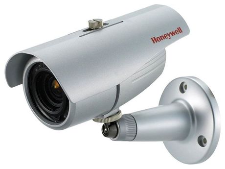 Caméra de sécurité Honeywell argentée fixée au mur.