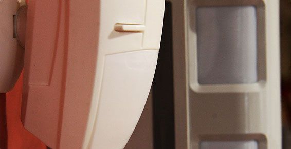 Détecteur de mouvement couleur crème sur un mur clair.