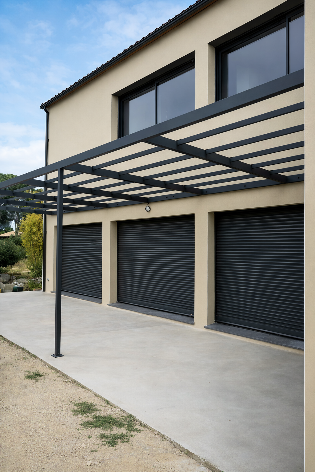Pergola en acier, vue extérieure d'une maison, une terrasse et des volets roulants gris anthracite.