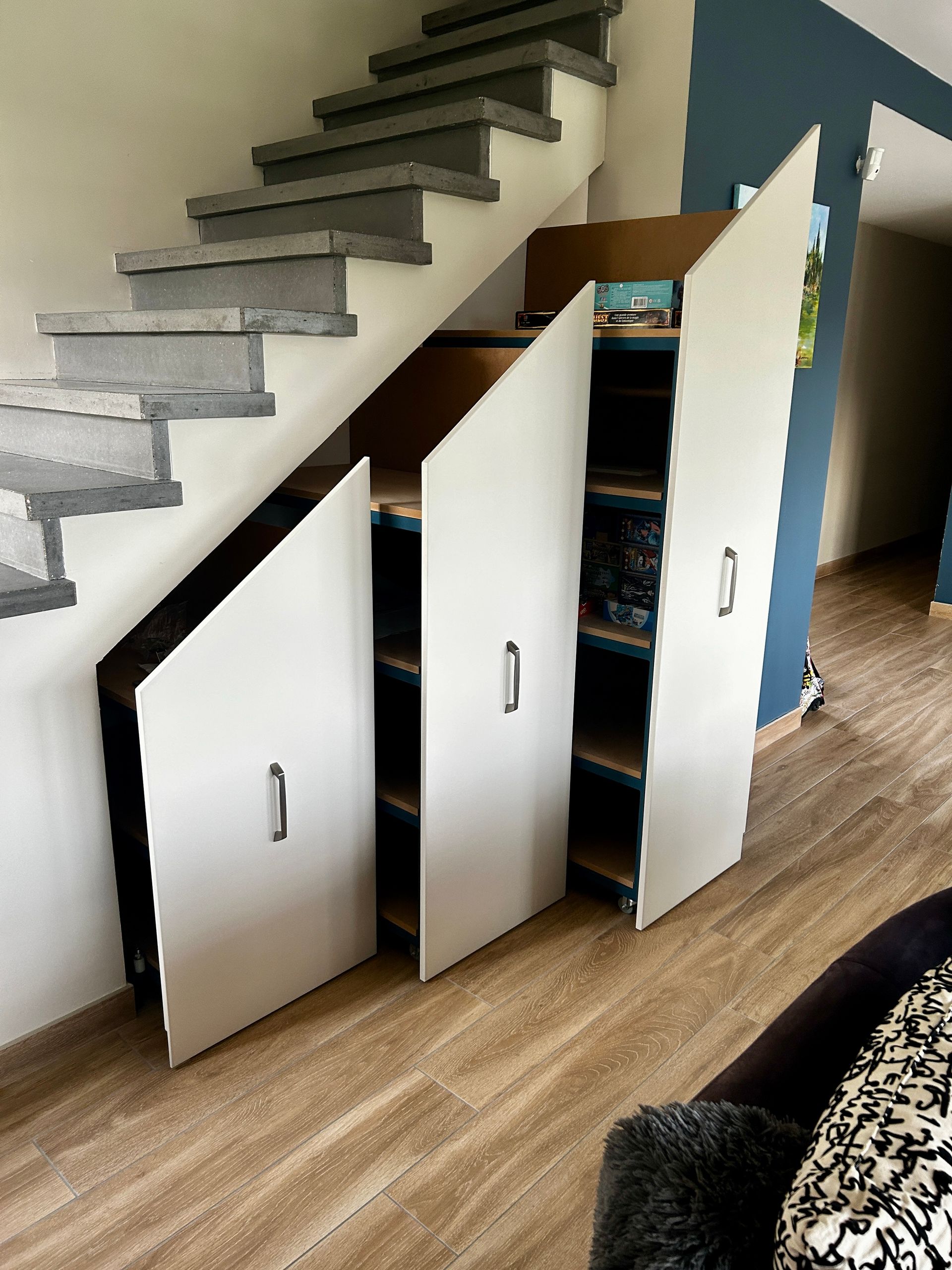 Meuble sous escalier en métal et bois blanc coulissant.