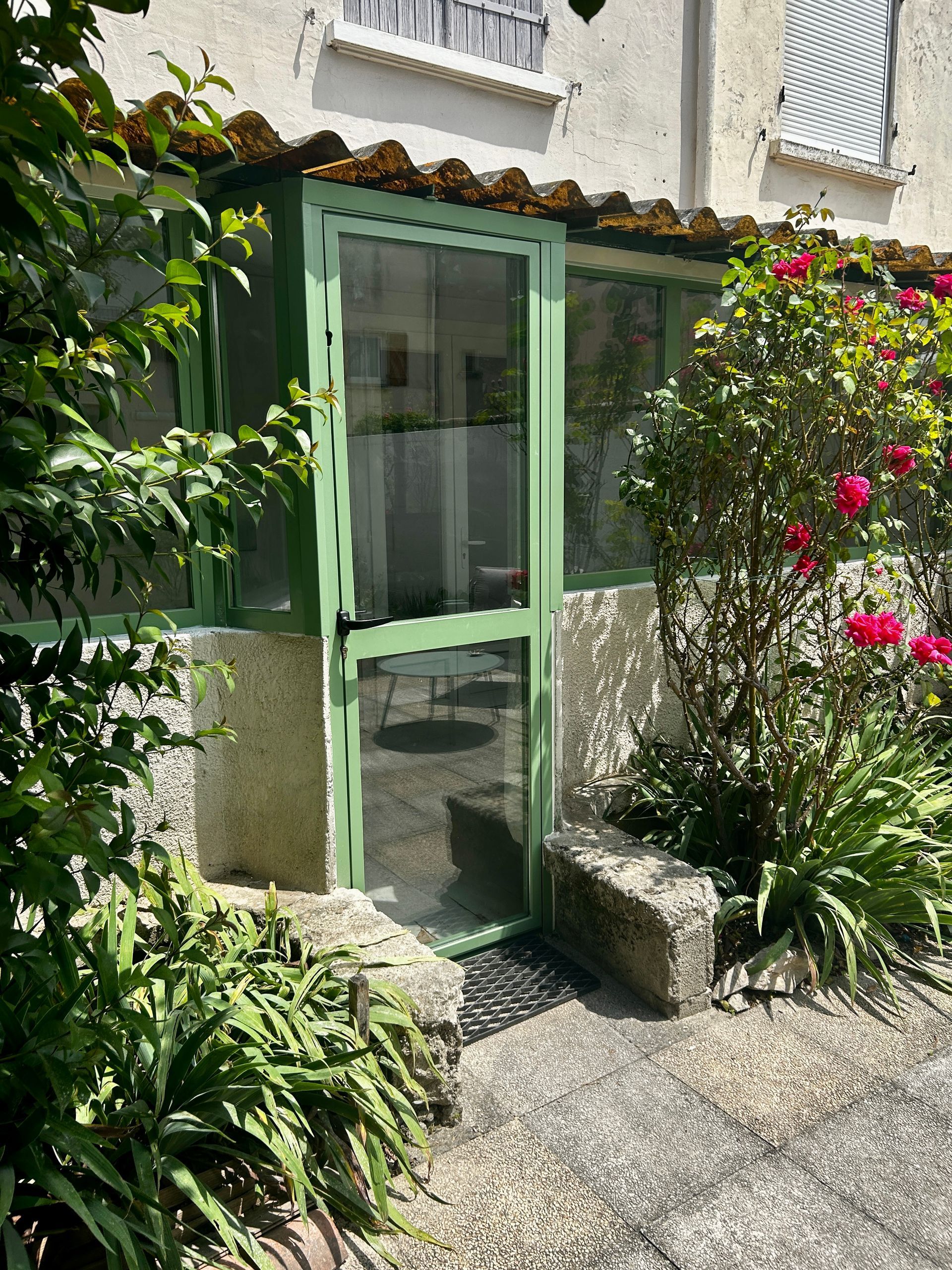 Porte vitrée en métal vert.