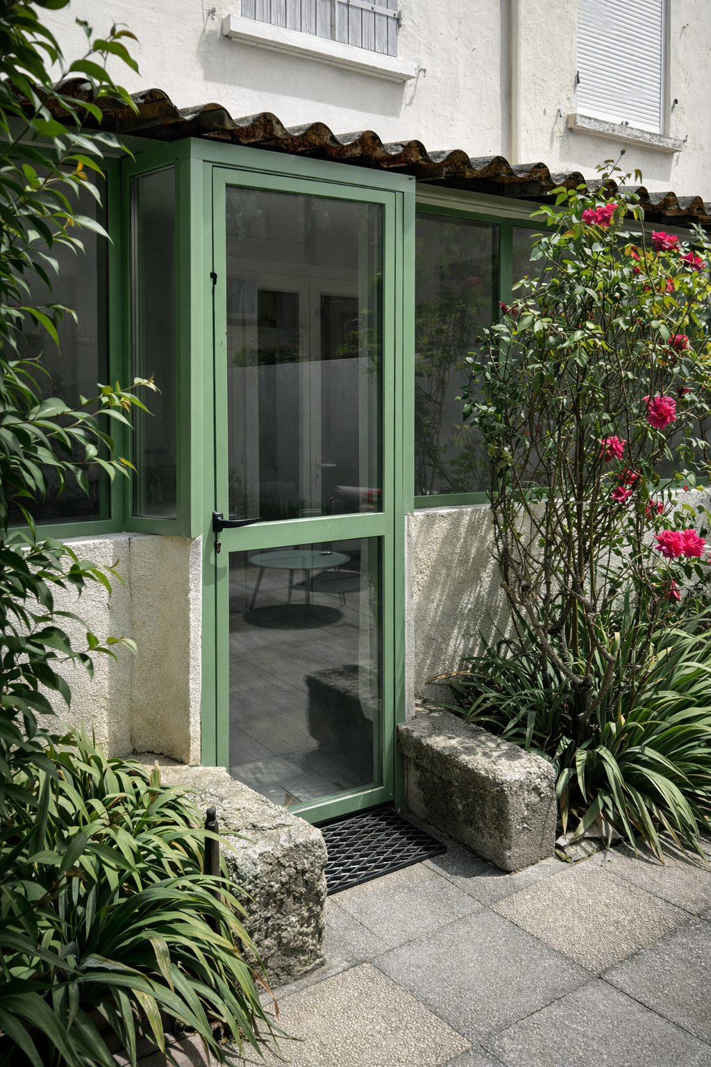 Porte vitrée en métal vert.