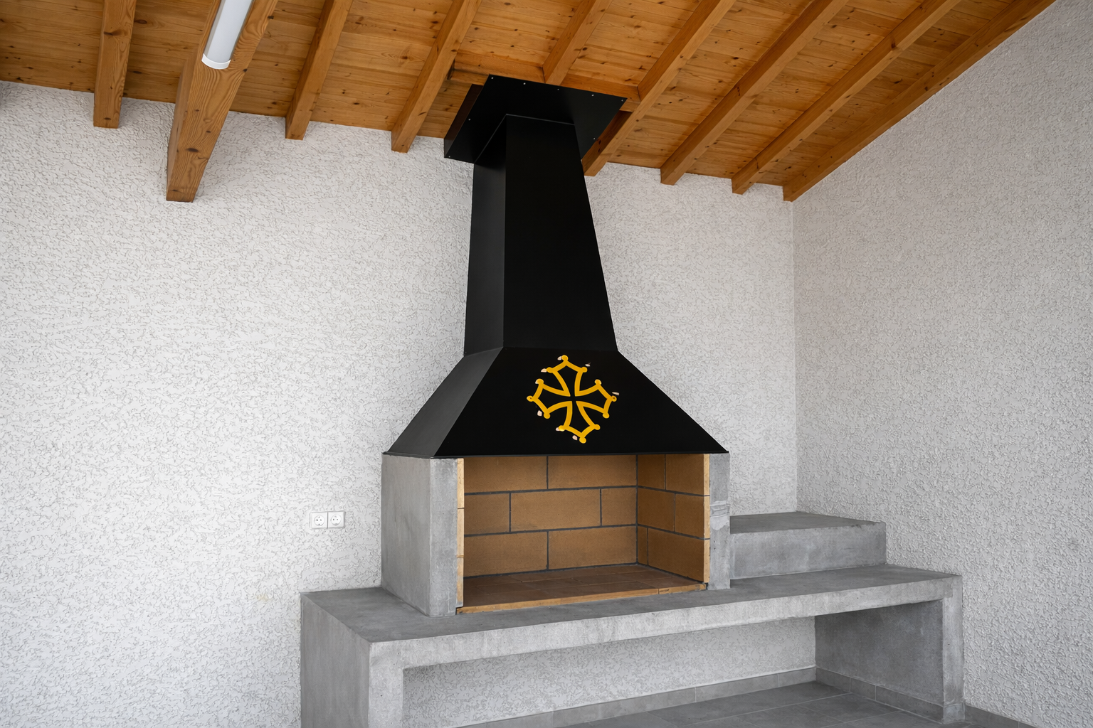 Barbecue extérieur en briques avec cheminée noire et comptoir en béton.