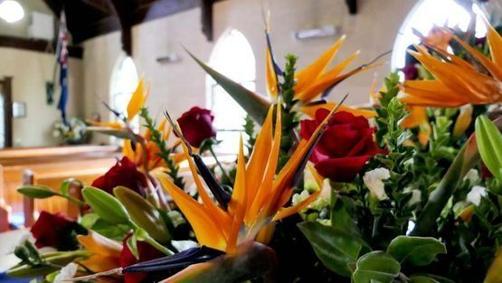 Un ramo de flores en una iglesia con una bandera al fondo.