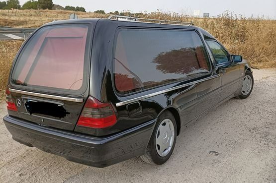 Un coche negro está estacionado al costado de la carretera.