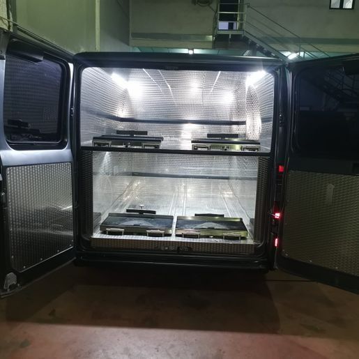 Una furgoneta con las puertas abiertas y un frigorífico dentro.